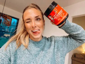 woman holding six star pre workout tub