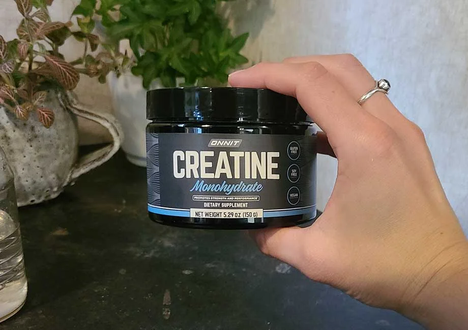 Someone holding a container of Onnit Creatine