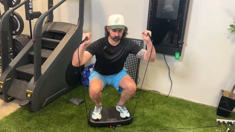 Our product tester squats with resistance bands on a Softgym Vibration Plate