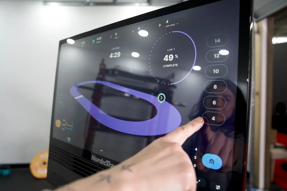 Woman using the touchscreen on the NordicTrack X24 Exercise Bike