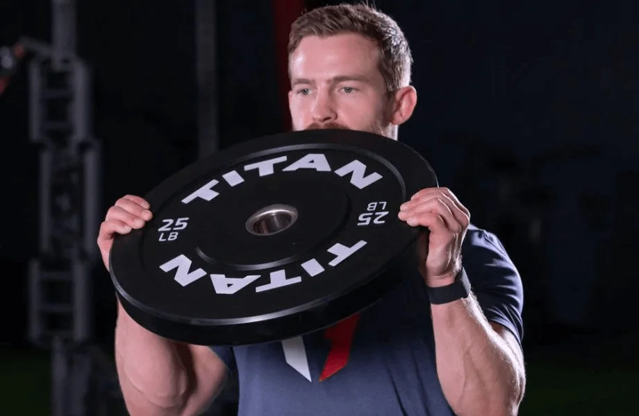 A man curling a 25-pound Titan Fitness Economy Bumper Plate