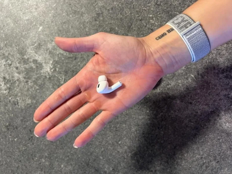 A hand holds out an Airpod Pro 2.