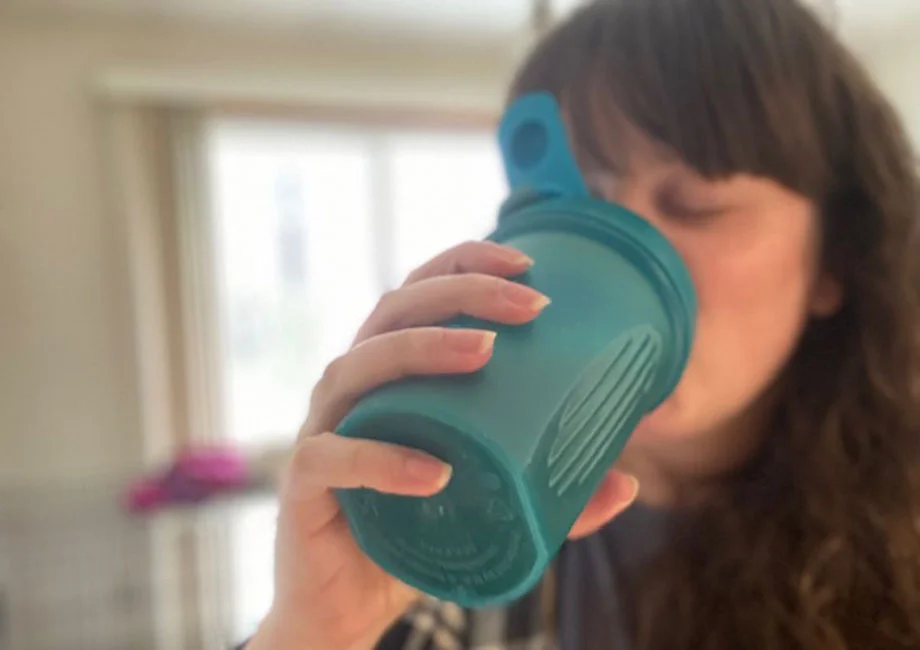 A person drink a Tone It Up Protein shake.