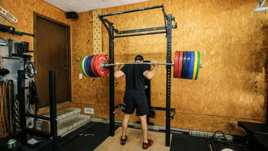 Man squatting heavy weight on the PRx Folding Squat Rack