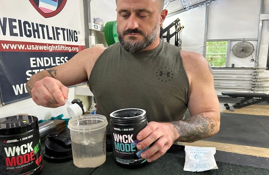 Our tester pouring a scoop of Jacked Factory Wick Mode pre-workout into their shaker bottle