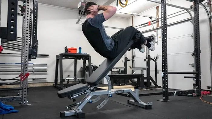 Man performing decline sit-ups on an adjustable weight bench