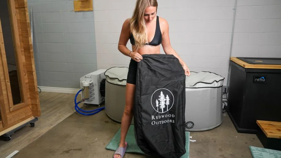 Woman holding carrying backpack for the in Redwood Outdoors Cold Plunge tub