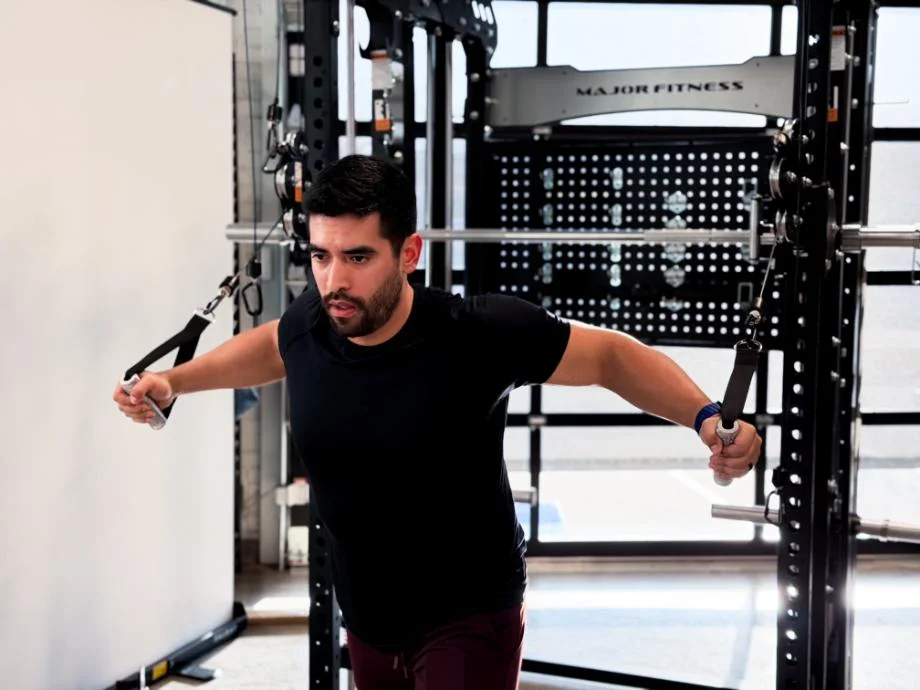 A man performs chest flyes while using the Major Fitness B17
