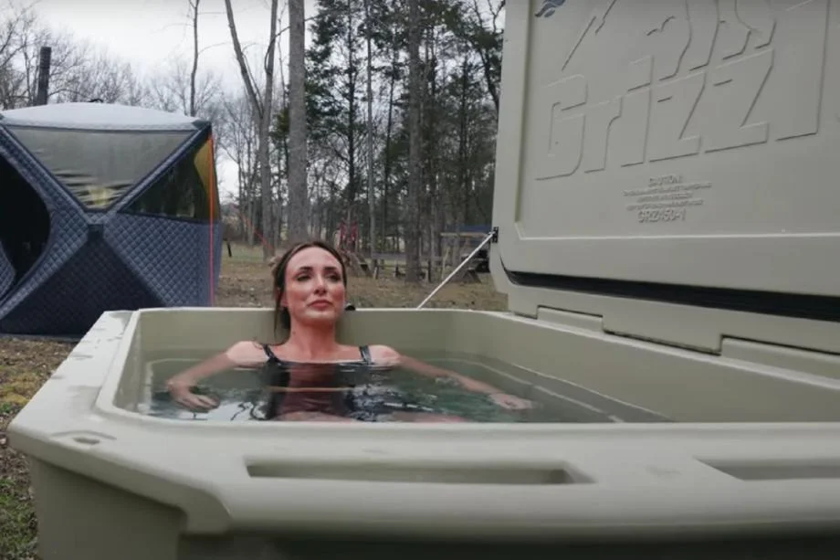 A woman sitting in the Desert Plunge Wide 450 cold plunge tub