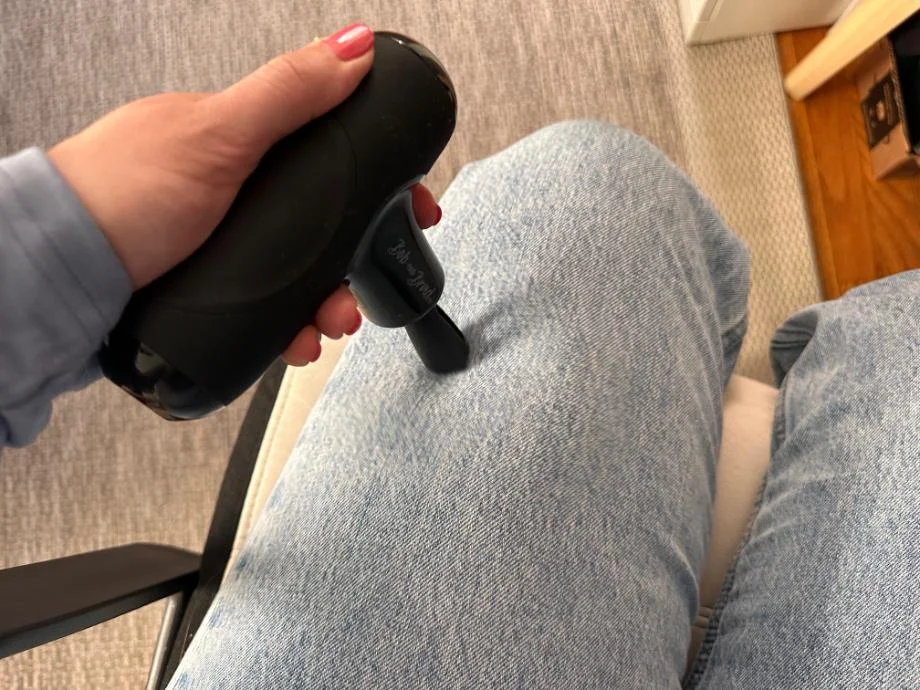 A person uses the Bob and Brad Q2 Mini Massage Gun on their leg