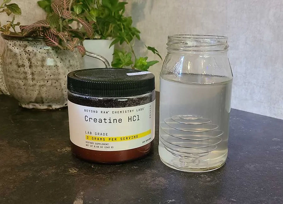 Container Of Beyond Raw Creatine Hcl Next To A Glass