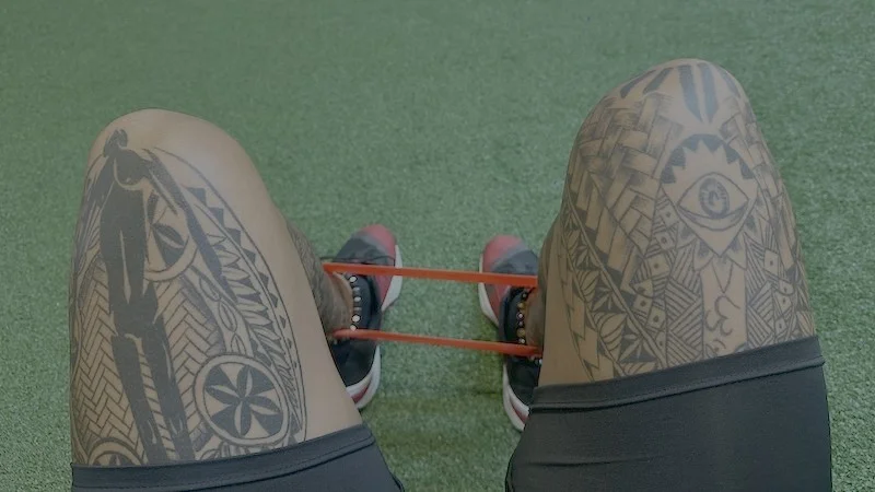 A person does hip openers with Iron Bull Mini Bands