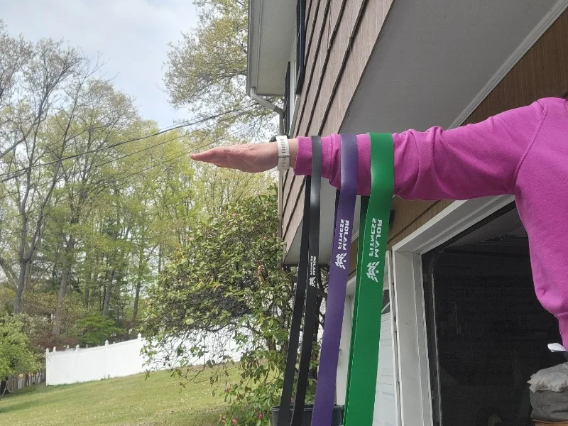 A set of Major Fitness Pull-Up Assist Bands hanging from a person's arm.