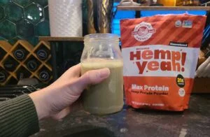 holding a glass of hemp yeah protein