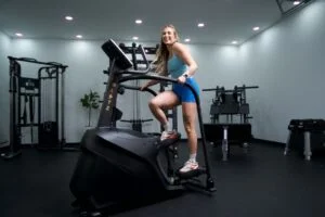 bells of steel blitz stepper full view standing on stepper holding side handles model looking at camera