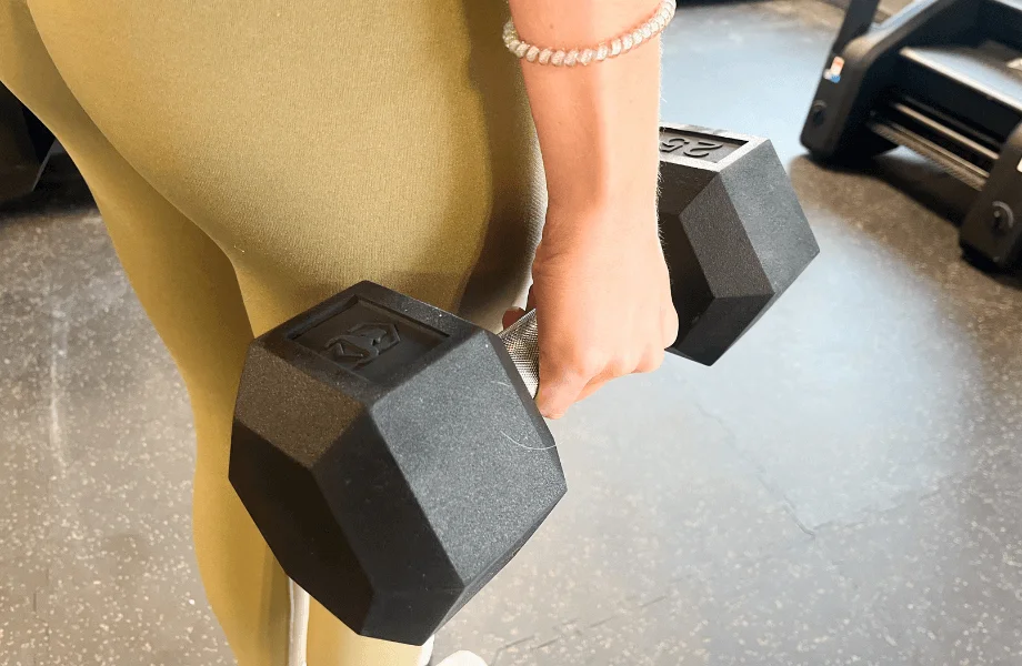 Our tester holding an Iron Bull Rubber Hex Dumbbell at their side