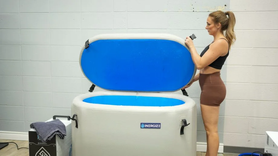 A woman opens the lid of the Inergize Cold and Hot Plunge Tub