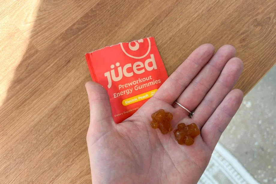 A person holding two of the Juced Pre-Workout Energy Gummies