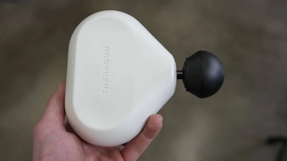 Theragun mini in Coop's hand.