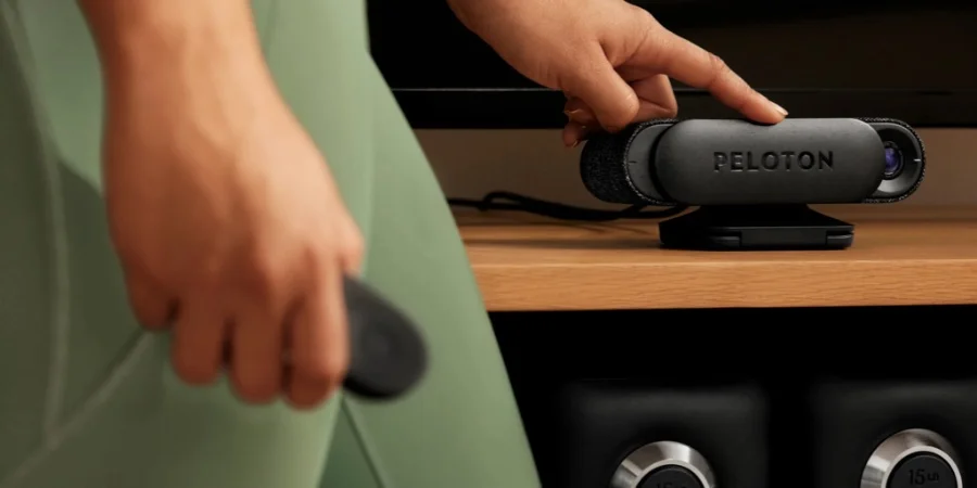 Woman closing the cover on the camera for the Peloton Guide