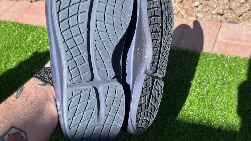 Looking at the tread on a pair of OOFOS OOahh Recovery Slides.