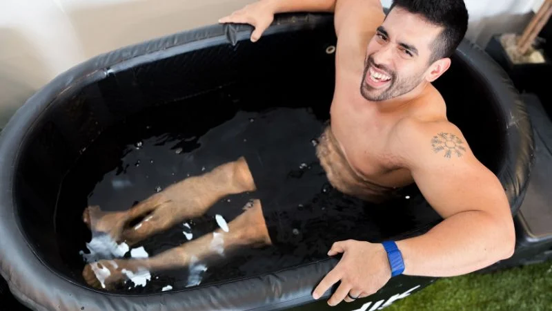 A photo from above of a man sitting in the Nordik Recovery cold plunge tub