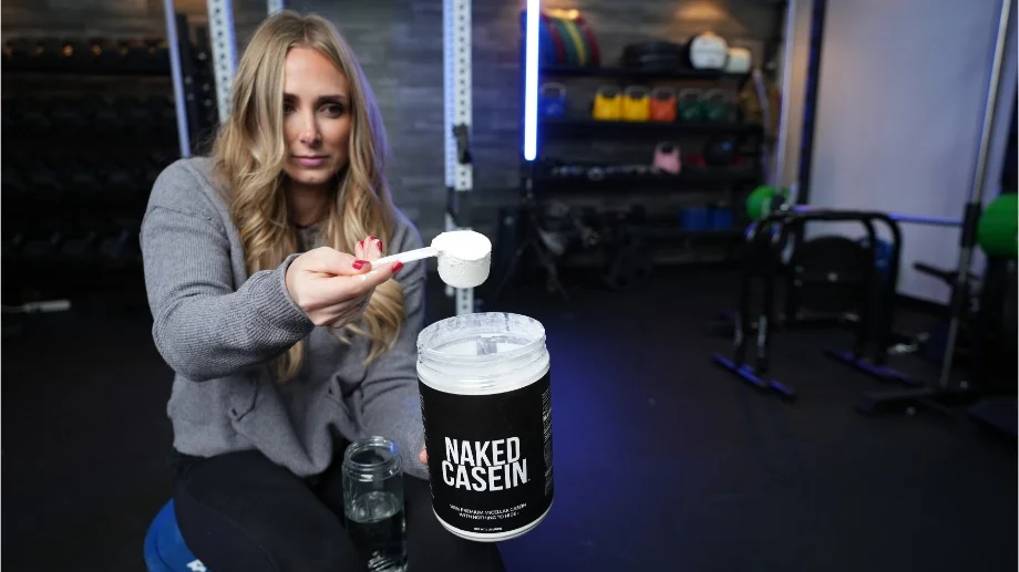 A woman scoops up some Naked Casein powder.