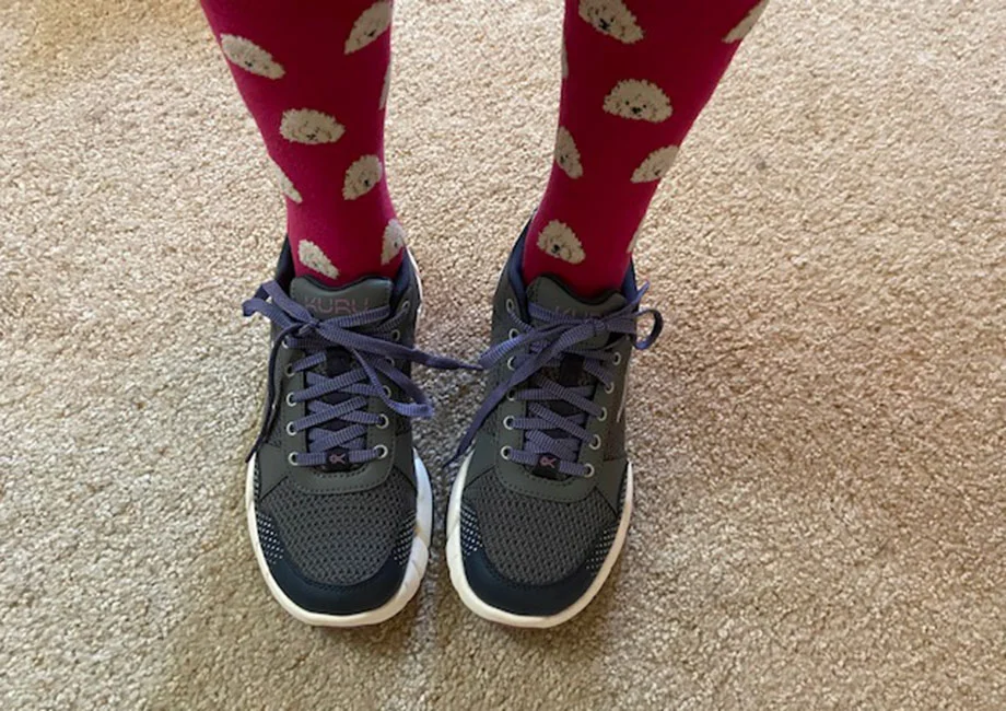 A person in cute red socks is wearing KURU QUANTUM 2.0 shoes.