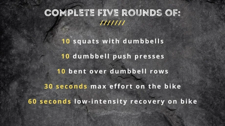 graphic that displays text Complete five rounds of: 10 squats with dumbbells 10 dumbbell push presses 10 bent over dumbbell rows 30 seconds max effort on the bike 60 seconds low-intensity recovery on bike