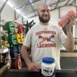Our tester smiles while shaking up a serving of Nutricost Pre-X Pre-Workout.