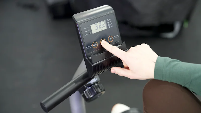 Woman using the monitor on the YOSUDA Recumbent Exercise Bike