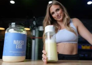 woman holding shaker of naked egg protein