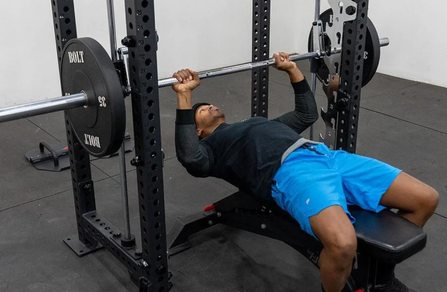 A person bench pressing on the Bolt Fitness Smith Machine