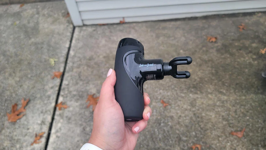 A person holding the Bob & Brad M7 Plus mini massage gun.