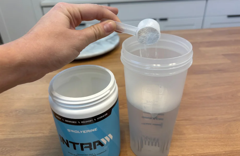 Our tester adding a scoop of Swolverine INTRA to their shaker cup