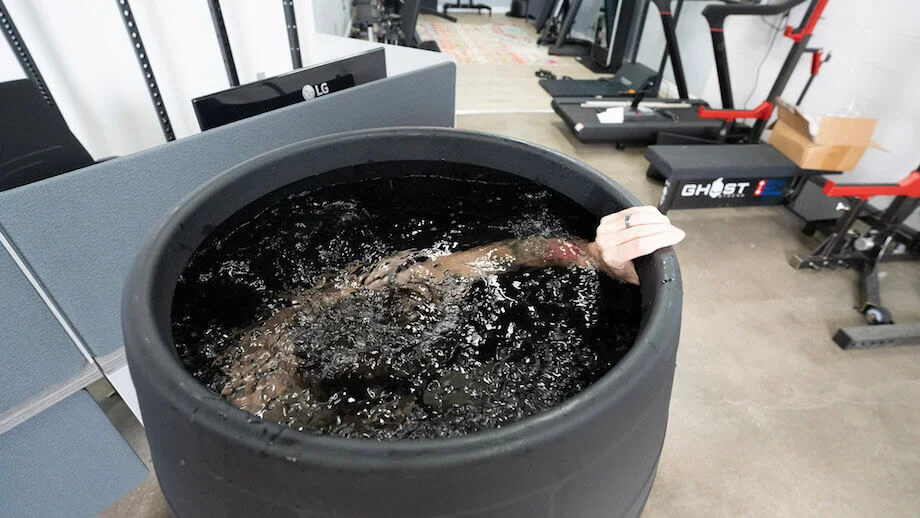 Someone completely submerged in an Ice barrel 