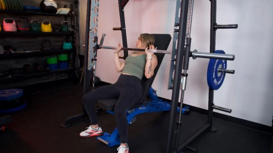 Full view of someone doing a bench press in the Titan Smith Machine.