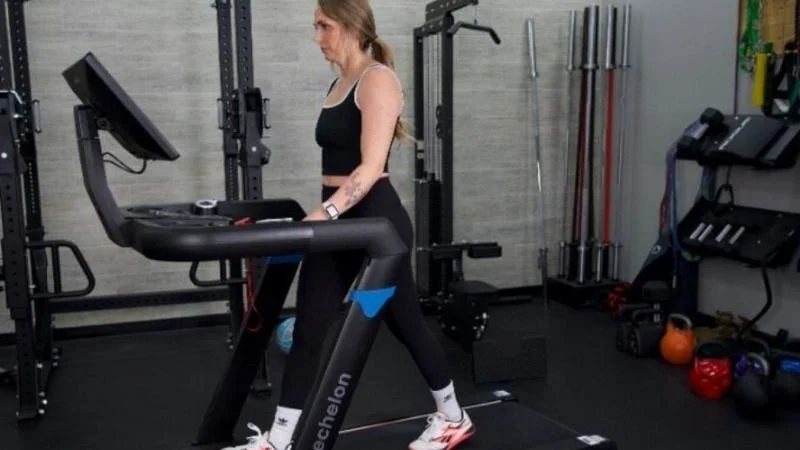 Side view of a woman Echelon Stride 8s treadmill.