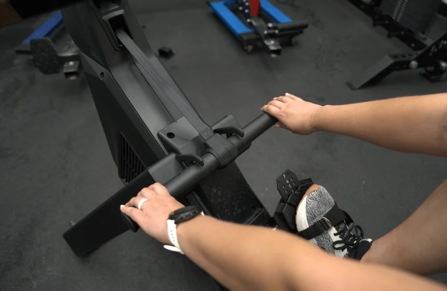 Our tester grabbing the handlebar of an Aviron rowing machine