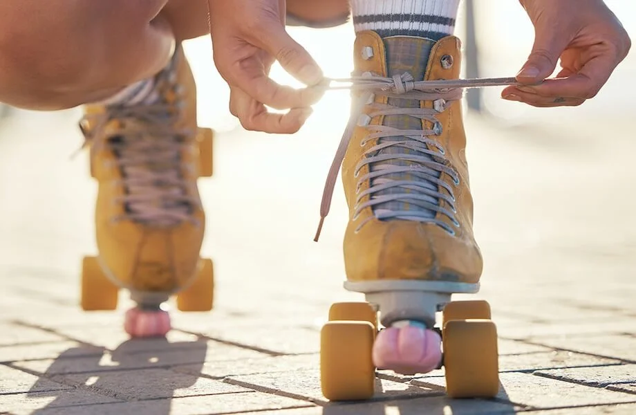 A person fixing the laces on their roller skates