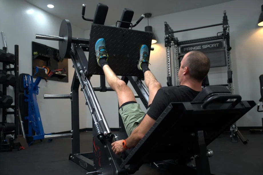 A view of Coop doing leg presses from behind on a Bolt Fitness Hack Squat Leg Press machine.