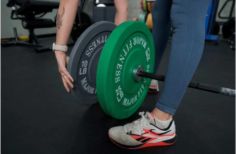 Our tester loading Major Fitness Low Bounce Bumper Plates onto a barbell