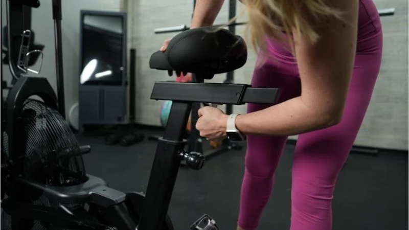 Our tester adjusts the seat height on a Bells of Steel Residential Air Bike.