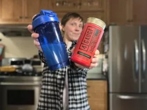 4 Gauge pre workout woman holding shaker and powder