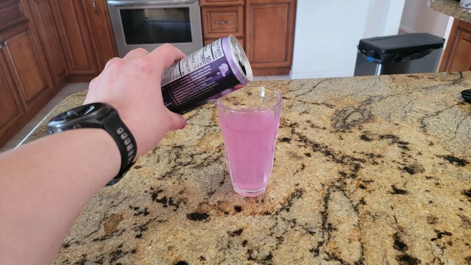 Pouring a can of Alani Nu into a glass