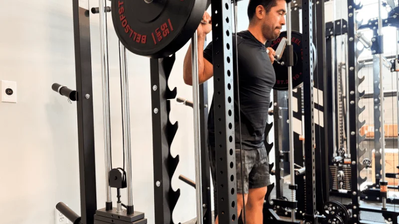 Our tester standing with a Smith machine barbell on their shoulders in the Major Fitness B52 Pro