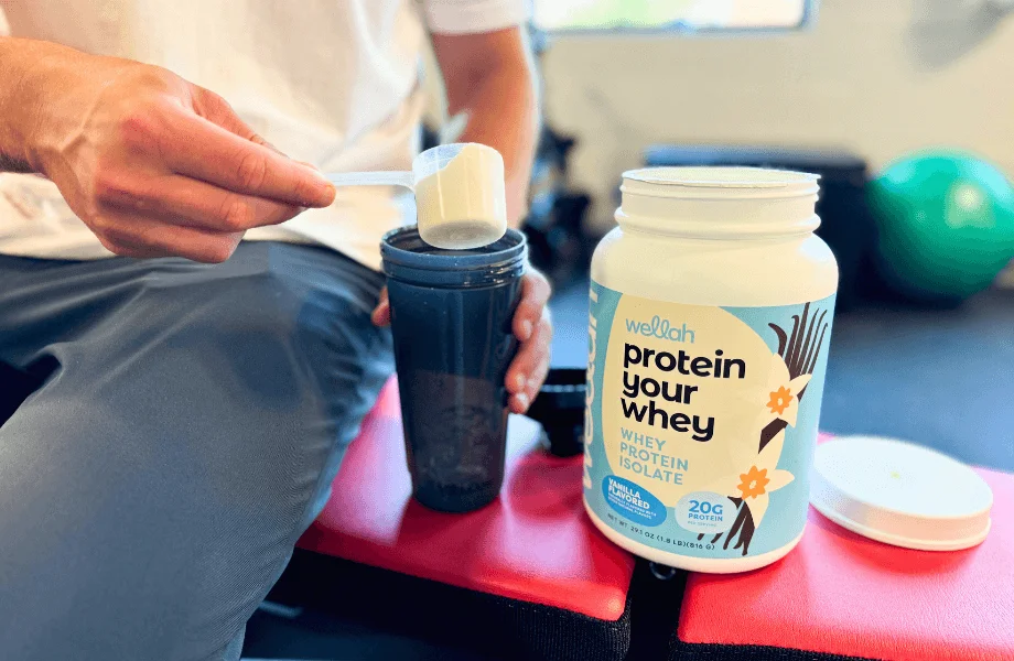 Our tester pouring a scoop of Wellah Protein Your Whey into their shaker bottle post-workout