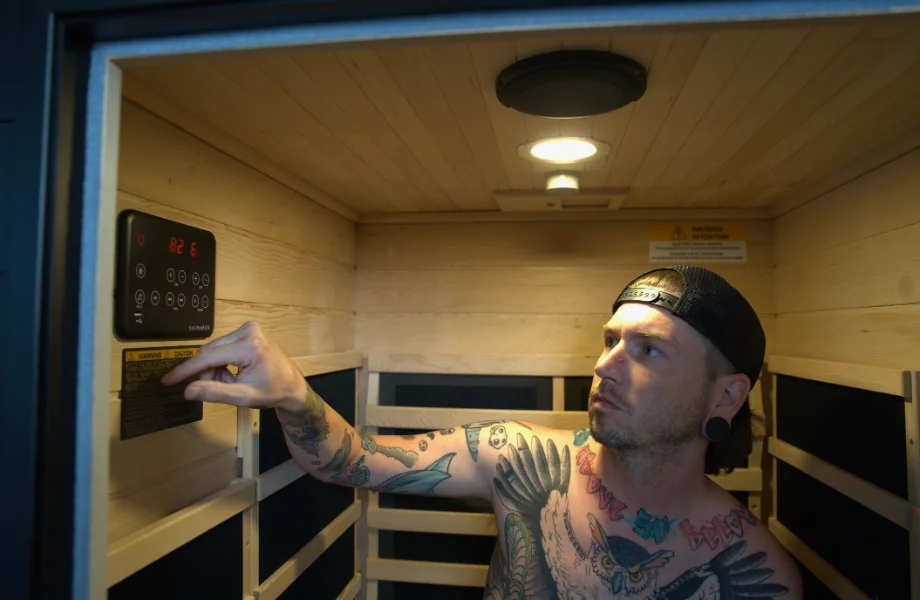 Our tester adjusting the settings of the SaunaBox Solara infrared sauna