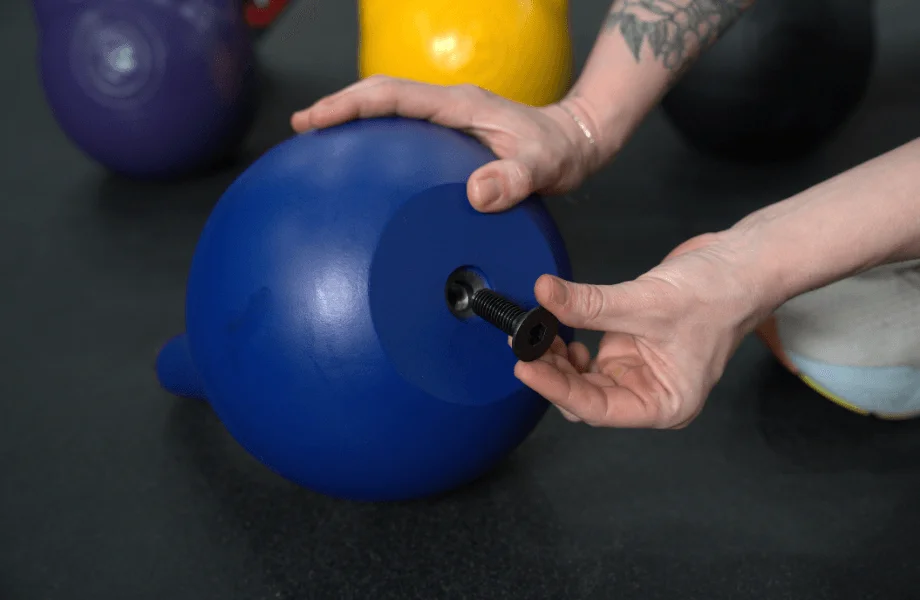 Our tester closing the exterior shell of the Bells of Steel Adjustable Competition Style Kettlebell