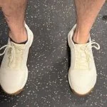 Looking down at the feet of a person wearing a pair of NOBULL Outwork Flex cross-training shoes.